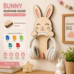 May include: A wooden bunny-shaped headphone holder with a light wood finish and pink accents. The holder is designed to hold headphones and has the text "BUNNY HEADPHONE HOLDER". The material thickness is 3mm. The design is cute and decorative.