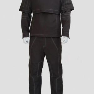 May include: A dark brown, two-piece outfit with white stitching. The top has a high collar and a layered design, with a vest-like overlay. The long-sleeved shirt has a short cape-like detail. The pants are straight-legged. The outfit is displayed on a mannequin.