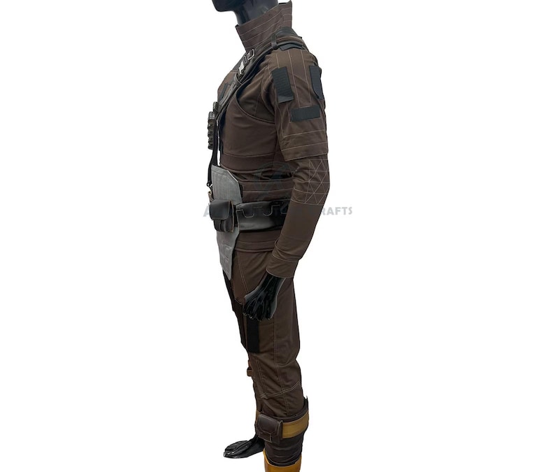 May include: A brown costume with a high collar, shoulder pads, and multiple pockets. The outfit includes a belt with pouches, gloves, and boots. The costume has a futuristic or military design.