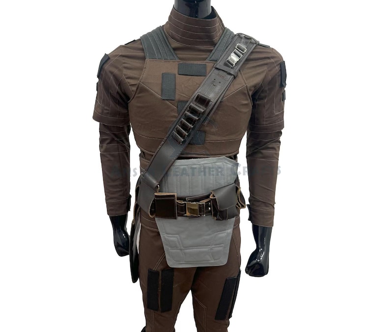 May include: A brown costume with a tactical vest, shoulder strap, and belt. The outfit includes a brown long-sleeved shirt and trousers. The costume has a grey and brown colour scheme, with black accents.