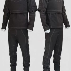 May include: Two matching black tactical outfits. Each outfit includes a high-collared top with a chest plate, long sleeves, and matching pants. White stitching accents the seams. The outfits are displayed on mannequins.