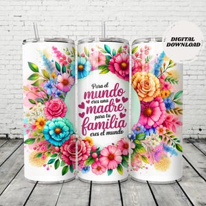 May include: White tumbler with a floral design featuring pink, blue, and yellow flowers. The tumbler has a straw and the text "Para el mundo eres una madre, para tu familia eres el mundo" in pink script.