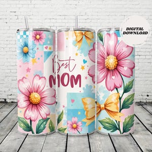 May include: Three stainless steel tumblers with floral and bow designs. The tumblers feature the text "Best Mom" and are decorated with pink, blue, and yellow flowers, bows, and hearts. Each tumbler has a straw.