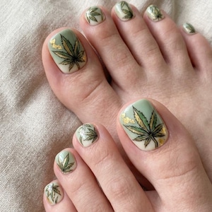 Unhas postiças com folhas de maconha 420, arte de unhas verde-sálvia com tema de cannabis, unhas postiças botânicas com folha de ouro, pedicure artesanal com tema de maconha, unhas para festivais.