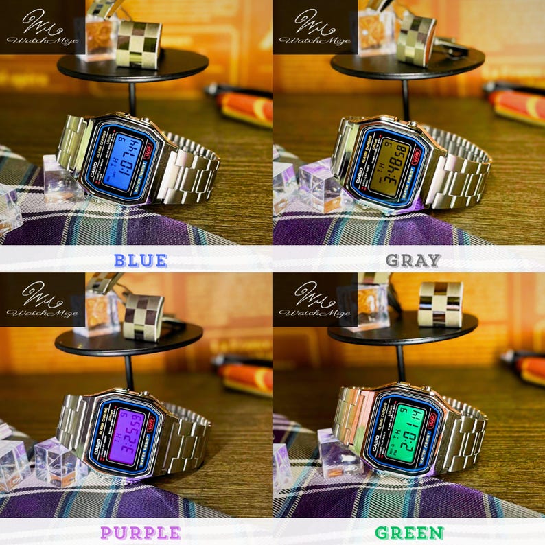 May include: A silver digital watch with a rectangular face and a metal strap. The watch face shows a blue digital time. The image also shows silver cufflinks and a small black display stand. The watch is a classic design.