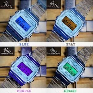 May include: A collection of Casio F-91W digital watches in blue, gray, purple, and green. Each watch displays the time and features a silver-tone band and a rectangular digital display. The watch face includes the Casio logo and model information.
