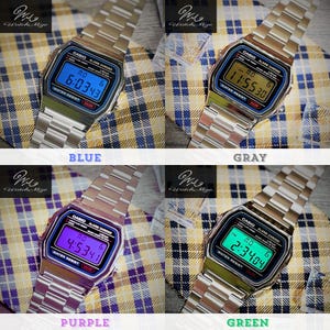 May include: Four digital Casio watches with silver straps and various coloured digital displays: blue, grey, purple, and green. Each watch has the Casio logo and text on the face. The watches are displayed on a plaid background.