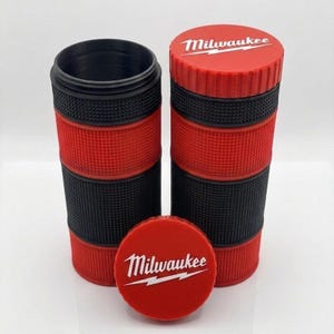 May include: Red and black cylindrical storage containers with the "Milwaukee" logo in white. The containers are made of textured plastic and have a screw-on lid. One container is open, revealing the interior.