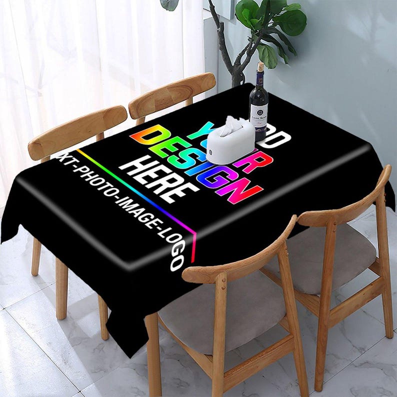 Może przedstawiać: Prostokątny czarny obrus z tęczowym tekstem z gradientem o treści YOUR DESIGN HERE oraz XT-PHOTO-IMAGE-LOGO. Na powierzchni stołu, otoczonego krzesłami, znajduje się białe pudełko na chusteczki oraz butelka wina.