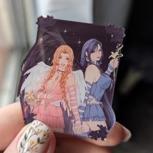 Könnte beinhalten: Ein quadratischer Aufkleber mit zwei Frauen im Anime-Stil. Eine hat lange orange Haare, weiße Flügel und ein rosa Kleid. Die andere hat lange blaue Haare und ein blaues Kleid. Beide halten Blumen vor einem Sternenhintergrund.