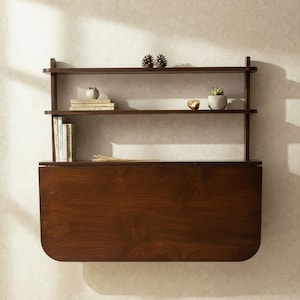 Walnut wall mounted murphy desk with shelves folded up flat against the wall. Space saving drop leaf folding table made of premium Baltic birch plywood for compact home office, apartment, and small space storage solution.