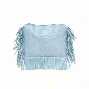 May include: A light blue clutch with a textured, snake-like pattern. The bag features long fringe on the sides and bottom, and a zipper closure. The bag is a soft, pastel blue color.