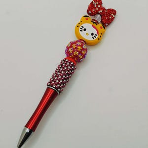 May include: A white ceramic mug with a black handle and the text "But First, Coffee" in a black, bold font. The mug is sitting on a wooden surface. The mug is approximately 4 inches tall.