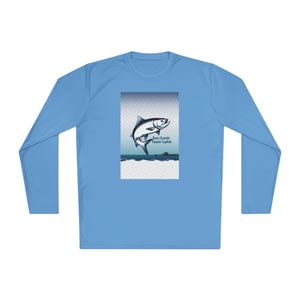 May include: Light blue long-sleeve shirt featuring a graphic of a leaping tarpon fish. The graphic includes the text "Boca Grande Tarpon Capital" in a blue font. The shirt is made of a soft, comfortable material.