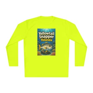 May include: A neon yellow long-sleeve shirt featuring a rectangular graphic print on the chest. The graphic depicts an underwater scene with a yellowtail snapper fish, coral reefs, and the text Yellowtail Snapper Yolanda in bold lettering.
