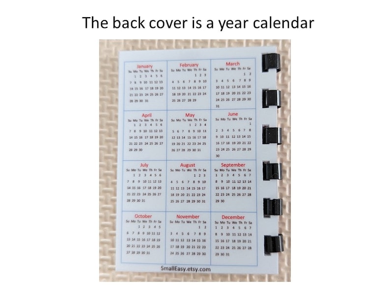 May include: A small, rectangular year calendar with a white background. The calendar displays all twelve months, with each month's days arranged in a grid. The text "The back cover is a year calendar" is at the top. The Etsy shop name is at the bottom.