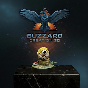 May include: A 3D-printed figurine of a yellow, one-eyed creature emerging from a cracked eggshell, with a Poké Ball nearby. The figurine sits on a small, mossy base. The background features a logo with a bird and the text "BUZZARD CRÉATION 3D".