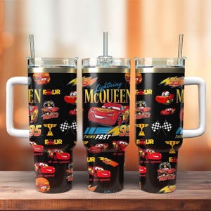 May include: Three black travel mugs with white handles and lids, featuring a Lightning McQueen design. The mugs have a repeating pattern of the character, the number 95, and the words "Think Fast". Each mug has a silver straw.