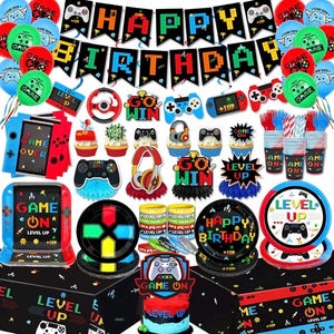Könnte beinhalten: Eine Sammlung von Partyzubehör mit Videospiel-Motiv. Enthält Luftballons, Banner, Teller, Becher und Kuchendekorationen. Das Farbschema ist rot, blau, grün und schwarz, mit Texten wie "Happy Birthday", "Level Up" und "Game On".