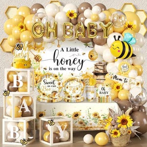 Puede incluir: Un conjunto de decoración para baby shower con temática de abejas. El conjunto incluye globos en amarillo, blanco y marrón, con las palabras "OH BABY" en dorado. El conjunto también incluye una tarta, platos, vasos y un letrero que dice "A Little honey is on the way."