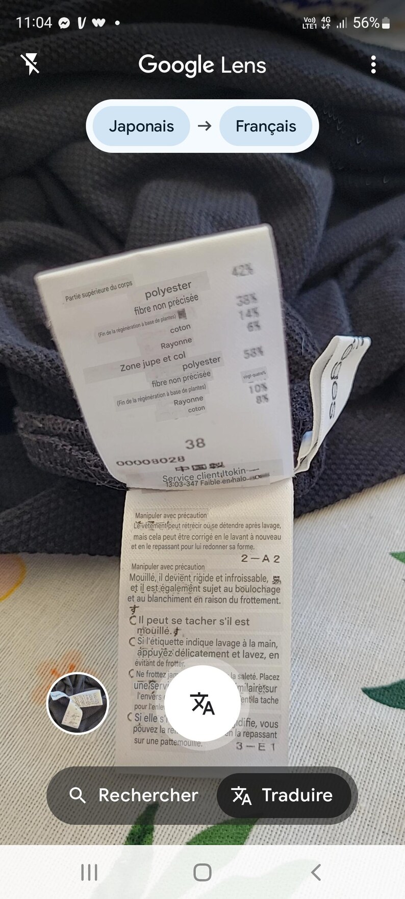 May include: A close-up of a clothing tag with text in French. The tag lists fabric composition percentages, including polyester, rayon, and cotton. The number 38 is visible, along with care instructions.
