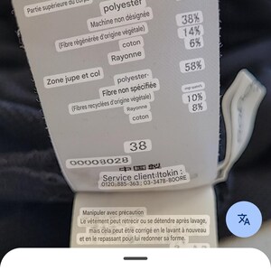May include: A clothing tag with text in French and Japanese, showing fabric composition percentages. The tag lists materials like polyester, cotton, and rayon. It also includes care instructions and a size 38.