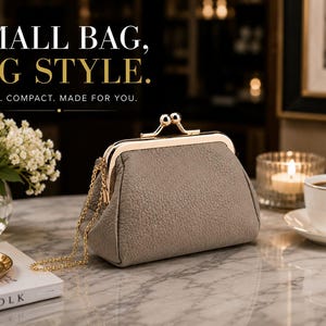 Pode incluir: Uma bolsa de mão na cor taupe com superfície texturizada e fecho de metal dourado tipo boquilha. A bolsa possui uma alça de corrente dourada fina e é exibida com o texto: SMALL BAG, BIG STYLE. CHIC. COMPACT. MADE FOR YOU.