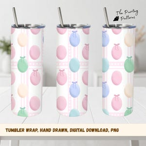 Op de afbeelding: Een witte tumbler met een herhaald patroon van pastelkleurige paaseieren in roze, blauw, groen en geel, geaccentueerd met roze strepen en stippen. De tumbler heeft een zilveren deksel en rietje. De tekst onderaan luidt "TUMBLER WRAP, HAND DRAWN, DIGITAL DOWNLOAD, PNG."