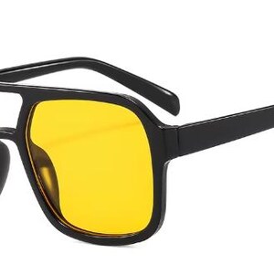 May include: Black sunglasses with yellow lenses. The sunglasses have a square shape with a double bridge and thick arms. The lenses are a bright yellow colour, and the frames are a matte black.