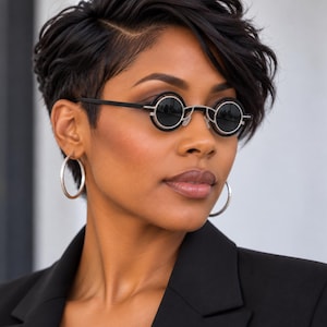 May include: Round sunglasses featuring black circular lenses framed by a thin silver metal rim and black outer rings. The eyewear includes slim black temples and a silver bridge, providing a distinct look with dark lenses and a metallic finish.