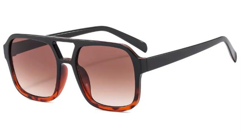May include: Square-framed sunglasses with a black top bar and arms. The lenses are gradient brown, and the lower frame has a tortoiseshell pattern. These sunglasses offer a stylish, retro look.