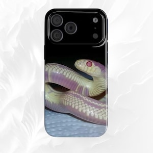 Op de afbeelding: Een telefoonhoesje met een close-up afbeelding van een slang. De slang heeft een crèmekleurig lichaam met roze strepen en een roze oog. De telefoonhoes is zwart aan de bovenkant en heeft een glanzende afwerking.