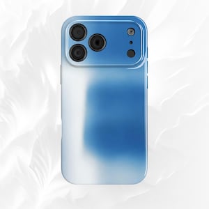 May include: A rectangular smartphone case featuring a smooth gradient design that transitions from a deep blue at the top to a soft white at the bottom. The case includes a raised camera cutout section with three circular lens openings and a flash.
