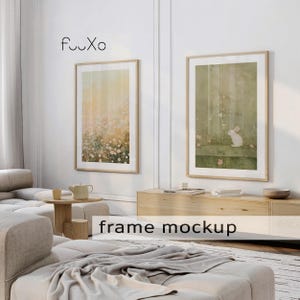 May include: Two framed art prints with light wood frames hang on a white wall. One print features a floral design in soft yellow and pink tones. The other print shows a white rabbit in a green setting. The text "frame mockup" is visible.