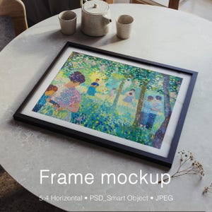 May include: A black rectangular frame containing a colorful impressionist-style painting of people in a garden setting. The artwork features vibrant green, blue, and yellow tones with figures scattered throughout a lush, dappled landscape scene.