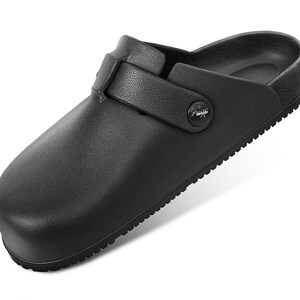 May include: A black slip-on clog with a textured surface, a rounded toe, and a side strap secured by a circular button featuring a small white insect graphic. The shoe has a molded footbed and a ridged sole for traction, providing a simple design.