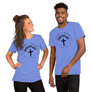 Könnte beinhalten: Zwei Personen tragen hellblaue T-Shirts. Die Shirts haben eine schwarze Grafik mit den Worten "Raising Little Disciples" und einem Kreuz, mit "Proverbs 22:6" darüber. Die Shirts sind aus weichem Material.
