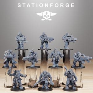 Puede incluir: Colección de figuras en miniatura grises, cada una representando un personaje con armas y armadura. Las figuras están dispuestas sobre soportes cilíndricos transparentes. El texto "STATIONFORGE" y un logotipo de calavera son visibles en la parte superior.