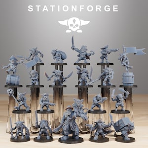 May include: A collection of gray miniature figurines, each depicting a goblin pirate in various poses, holding weapons, flags, and other accessories. The figurines are displayed on clear stands, with the word "STATIONFORGE" and a skull logo in the background.