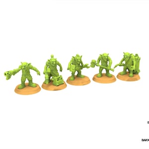 Puede incluir: Cinco figuras de fantasía en miniatura verdes sobre bases beige. Cada figura está en una pose diferente, sosteniendo varias herramientas y armas. Las figuras están sobre un fondo blanco. El texto "DESIGNED BY DAKKADAKKA.STORE" está en la esquina inferior derecha.