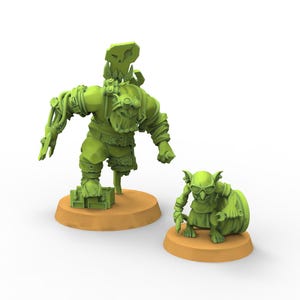 Puede incluir: Dos miniaturas de fantasía verdes sobre bases marrones. Una es una figura grande, de aspecto robótico, con gafas y brazos mecánicos. La otra es una criatura más pequeña, parecida a un goblin, con gafas y un barril. Las figuras son detalladas y estilizadas.