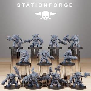 May include: A collection of gray miniature figurines of goblin-like creatures, each holding weapons such as guns, blades, and saws. The figurines are displayed on black stands. The word "STATIONFORGE" is printed at the top.