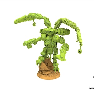 Puede incluir: Una figura de robot en miniatura de color verde lima, detallada, con múltiples brazos articulados y un arma. La figura está montada sobre una base de color marrón claro. El diseño incluye un detalle de calavera en un brazo. El texto "DAKKADAKKA.STORE" es visible.