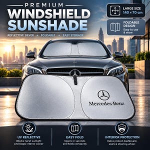 May include: A silver, foldable windshield sunshade with the Mercedes-Benz logo printed on the right side. The sunshade is displayed in front of a car, with text indicating a large size of 140 by 70 cm, UV reflective material, and easy storage.