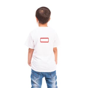 May include: A plain white short-sleeved t-shirt featuring a small, rectangular red outline graphic centered on the upper back. The shirt is paired with blue denim jeans, shown from a rear perspective against a solid white background.