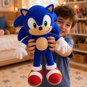 Puede incluir: Un peluche tejido a mano en ganchillo del personaje Sonic the Hedgehog, con cuerpo azul brillante, hocico y vientre color canela, guantes blancos y zapatillas rojas y blancas con detalles amarillos. El peluche tiene ojos verdes y nariz negra.