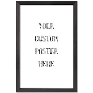 May include: A framed poster with the text "YOUR CUSTOM POSTER HERE" in a black, handwritten-style font. The poster is set against a white background and framed in a black wooden frame.