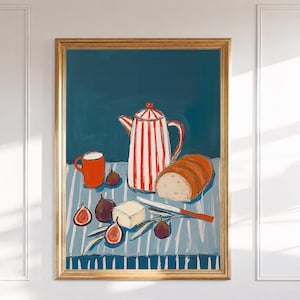 May include: A framed art print featuring a red and white striped teapot, a solid red mug, a loaf of bread, a block of butter, and several figs arranged on a blue and white striped tablecloth against a solid dark teal background.
