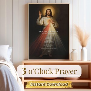 以下が含まれることがあります： 光輪のあるイエスの額装されたプリント。白とクリーム色のローブを着ており、胸から赤と白の光が発せられています。「3 O'Clock Prayer」の文字が上部にあり、その下にテキストが続きます。プリントは、花瓶のある木製の棚に飾られています。