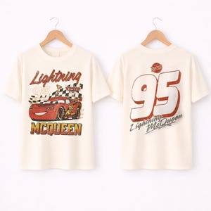 Puede incluir: Camiseta color crema con un gr&aacute;fico de Rayo McQueen de la pel&iacute;cula Cars. La parte delantera muestra el coche, el n&uacute;mero 95 y el texto "Lightning McQueen". La parte trasera de la camiseta tambi&eacute;n tiene el n&uacute;mero 95 y el logotipo de Lightning McQueen.